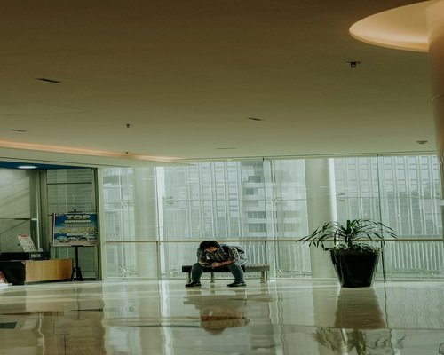 Person feeling tired sitting at a modern desk in Jakarta office